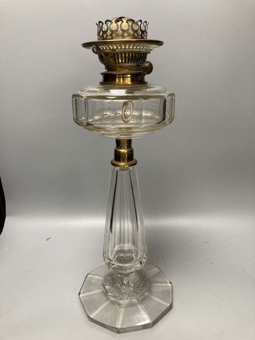 A late 19th century cut glass oil lamp with floral embossed shade, 61cm high including shade